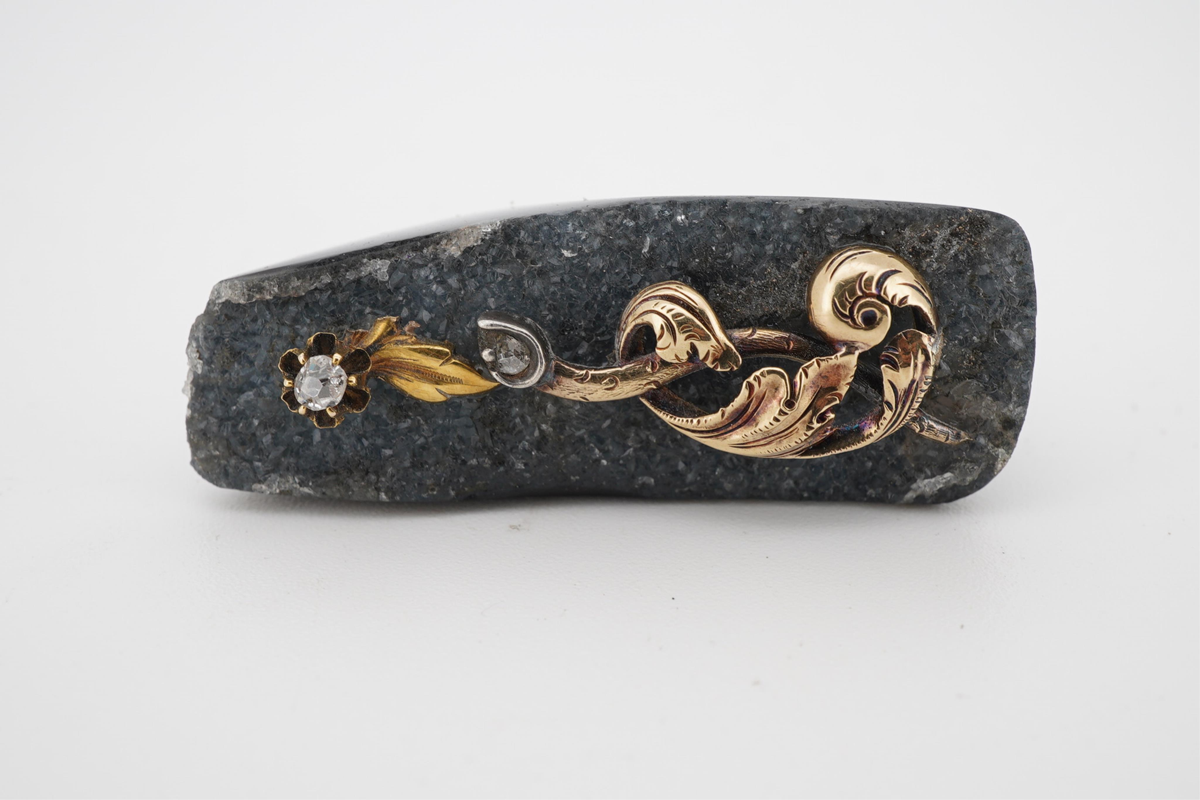 An unusual quartz ring, with a yellow metal and two stone diamond set scrolling foliate surmount, size N/O.
